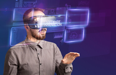 Businessman looking through Virtual Reality glasses with SOFTWARE INNOVATION inscription, new...