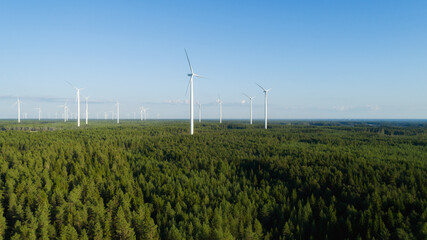 Aerial view of windmills in green forest in Finland. Wind energy for clean environment