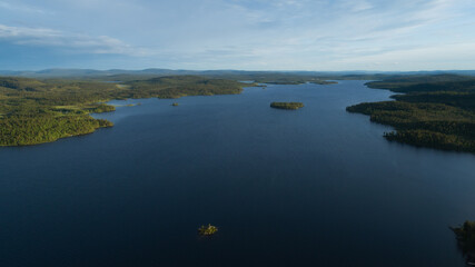 Fototapeta premium Aerial vibrant summer view of an island and skerries in the lake Inari, scandinavian landscape, shot from drone