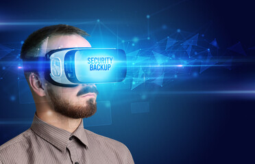 Businessman looking through Virtual Reality glasses with SECURITY BACKUP inscription, cyber security concept