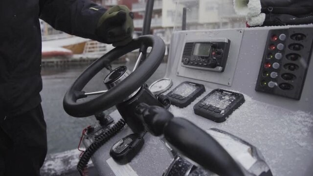 Turning a steering wheel of a motorboat harbour in slow motion