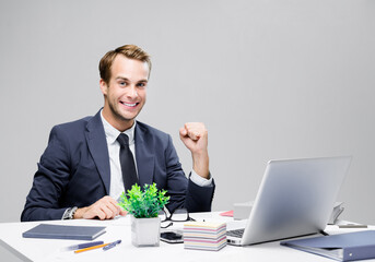 I have done it! Image of happy confident businessman in black suit with laptop computer at office. Success in business, job and education concept.