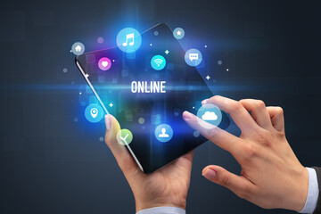 Businessman holding a foldable smartphone with ONLINE inscription, social media concept