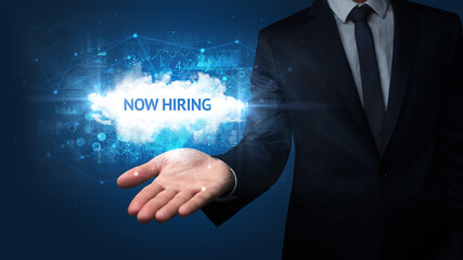 Hand of Businessman holding NOW HIRING inscription, successful business concept