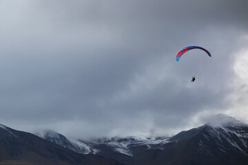 paraglider flies on a background of mountains   