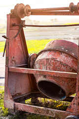 Old Rusty Abandoned Cement Mixer Machine beside the road in a village