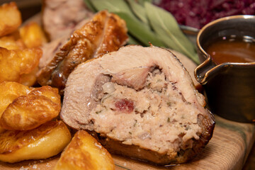 A delicious plate of Christmas Spiced Cranberry Stuffed Christmas Legs with spiced red cabbage and apple and fluffy roast potatoes, budget Christmas dinner concept