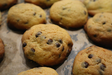 Tasty cookies with chocolate chips on baking tray
