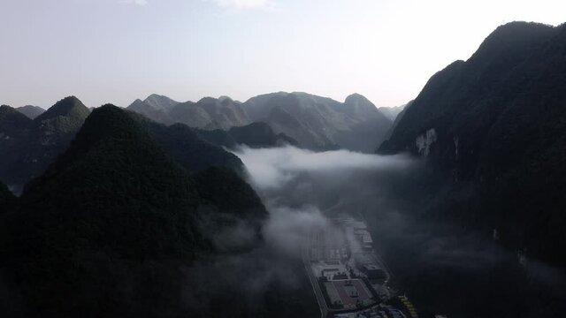 Dramatic sunset over cloudy karst mountain scenery, aerial view