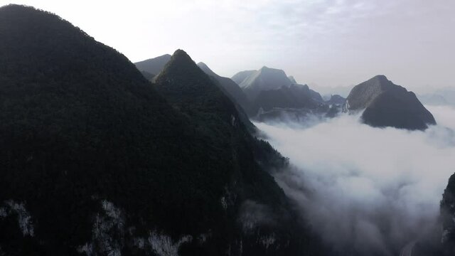 Dramatic Chinese karst mountain landscape, sunset cloudy aerial view