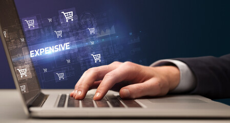Businessman working on laptop with EXPENSIVE inscription, online shopping concept