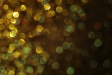 Golden bokeh background with soft light and circular reflections. Warm abstract texture ideal for festive themes, celebration, luxury, or elegant design elements