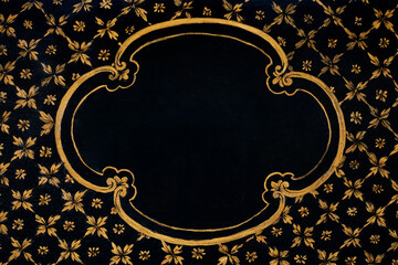 Golden frame painted on black wooden texture background with floral decoration