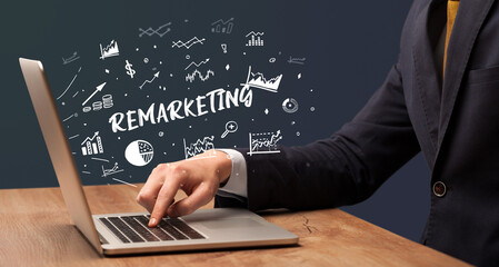 Businessman working on laptop with REMARKETING inscription, modern business concept
