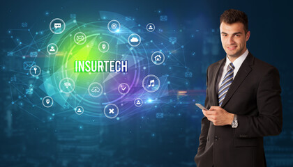 Businessman thinking in front of technology related icons and INSURTECH inscription, modern technology concept