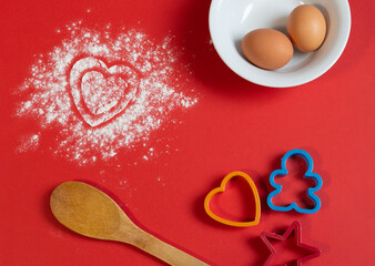 Bakery products. Flour is scattered on the table in the form of hearts. Form for gingerbread....