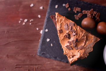 Homemade fresh bake sweet dessert organic delicious traditional dark chocolate cake layer frosting with glaze fudge salted cacao cream cheese serve with coffee tea on wooden table