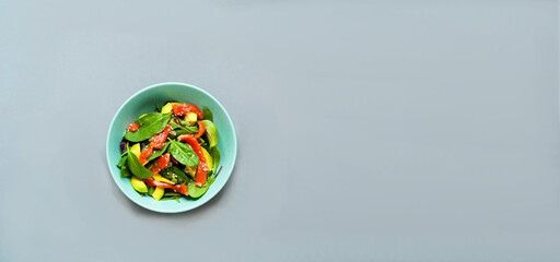Salmon Salad with spinach and avocado in green plate on gray background.  Concept health-conscious. Close-up
