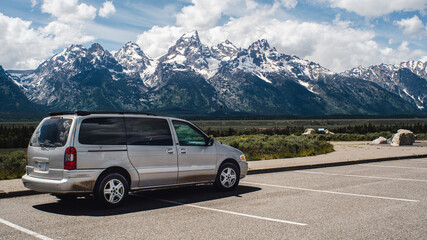 Fototapeta na wymiar campervan parked with a view of large mountains grand tetons