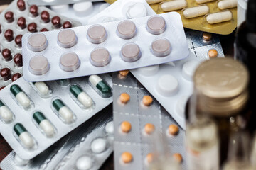 Colorful pills and capsules on wooden table