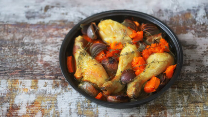 Chicken legs baked with pumpkin and blue onions in a pan. Delicious healthy lunch.