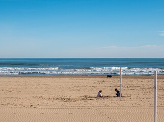 Fototapeta na wymiar Children playing in the sand on the beach