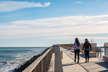 People walking along the harbor promenade