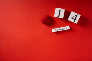 Wooden calendar with date 14 February, on red background, top view