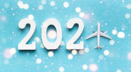 on a blue background white wooden numbers 2021 lie, instead of 1 plane. top fire bokeh fireworks