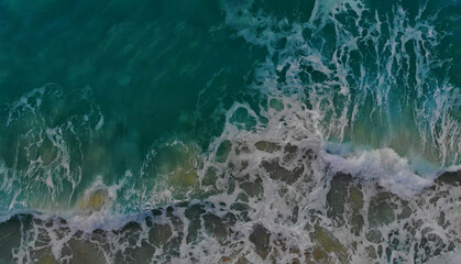 Turquoise ocean water wave view from height to the shining and sparkling surface.