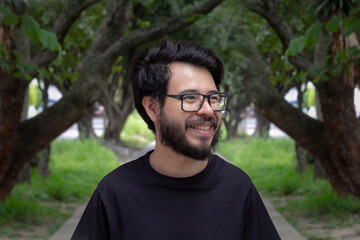 smiling mexican man with beard and glasses at park