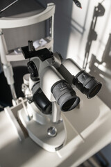 Fototapeta na wymiar Oculars with lens of ophthalmological diagnostic equipment on doctor workplace