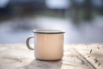 White metal coffee cup, mug on old wooden table