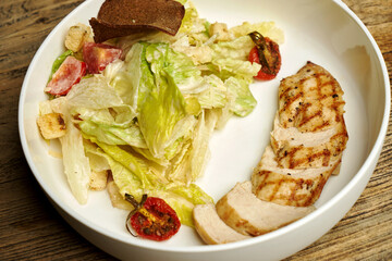 Caesar salad with lettuce, chicken and cheese.