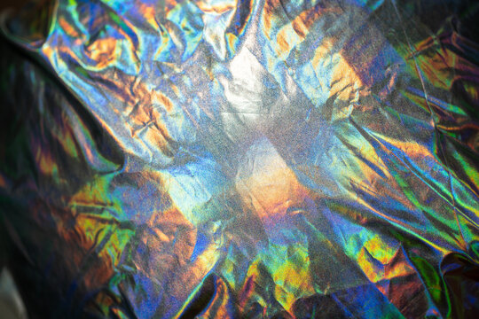 Iridescent fabric holographic background. Crumpled surface