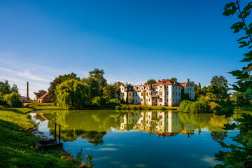 Fototapeta na wymiar Güttmannsdorf Castle, a neo-Gothic castle on a small lake in Dobrocin, Poland.