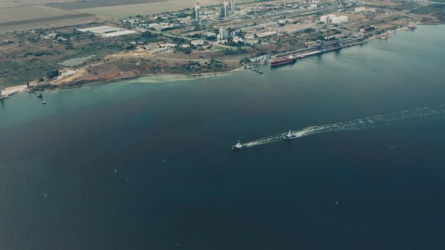 Aerial drone view of tugboats going across the bay.