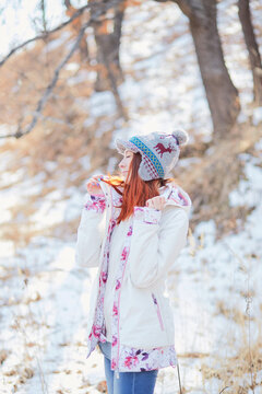 Graceful model laughs happily, turning away from the camera. Photoshoot during a walk in a winter forest in eastern Russia