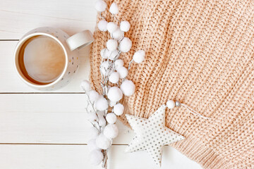 Fototapeta na wymiar Winter background with cup of cappuccino, knitted sweater, fluffy branch and white star.