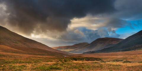 sunset over the mountains with dark clouds on one side in Scotland Isle of Skye 