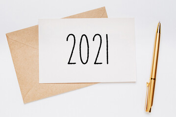 2021 note with envelope and gold pen on white background. merry christmas and New Year concept