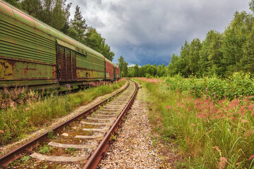 Fototapeta na wymiar Obsolete railway wagons, abandoned on old railroad tracks