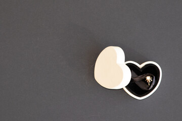 Caja destapada con forma de coraz&oacute;n con anillo en interior de compromiso 