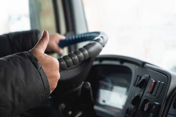 Truck driver is showing a thumbs up gesture close up. Best transportation service.