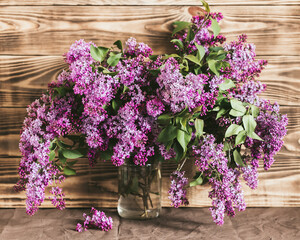 Bouquet of lilac in a jar on a wooden background