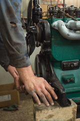 Car mechanic repairing an engine. Mechanic working on car engine. Mechanic workshop.