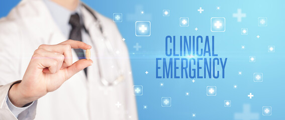 Close-up of a doctor giving a pill with CLINICAL EMERGENCY inscription, medical concept