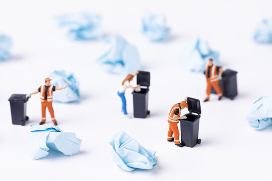 A Selective Focus Shot Of Used Paper And Waste Collector Toys On A White Background