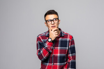 Fototapeta premium Young handsome man thinking over gray background
