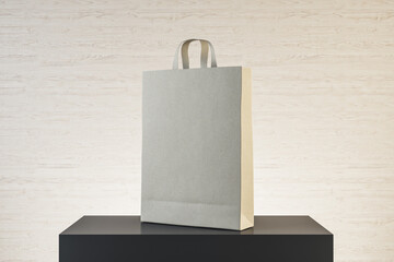 Fototapeta premium Paper bag with handles on podium.